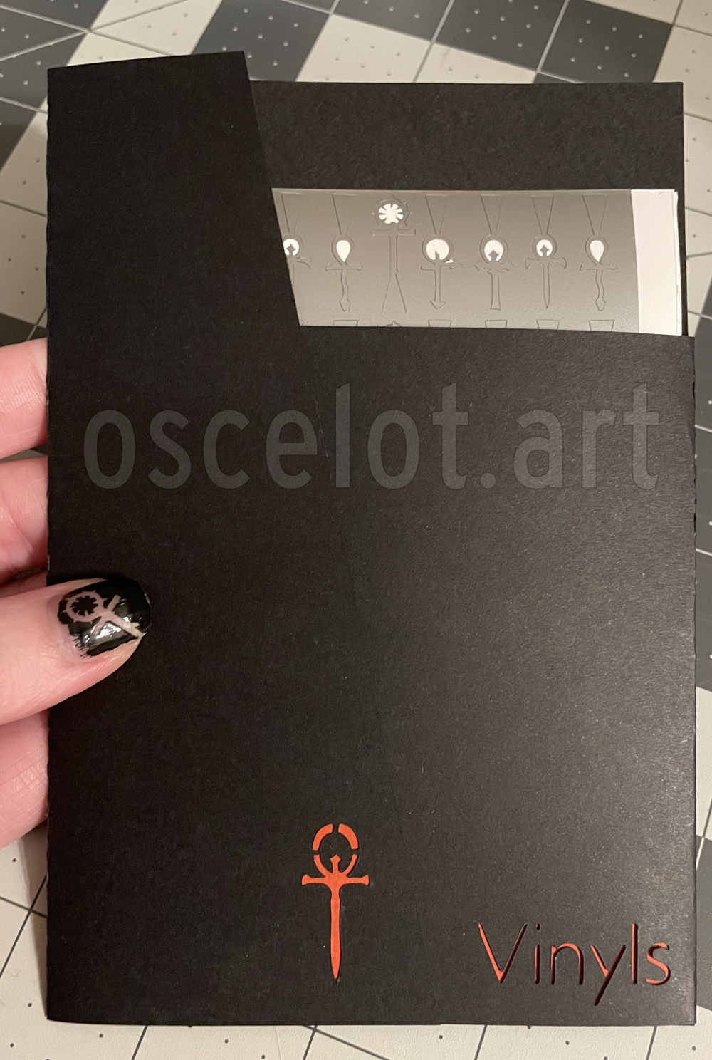 The finished envelope is black, with cutout sections containing the Vampire v5 ankh and the word Vinyls. The finished vinyls slot perfectly into it.